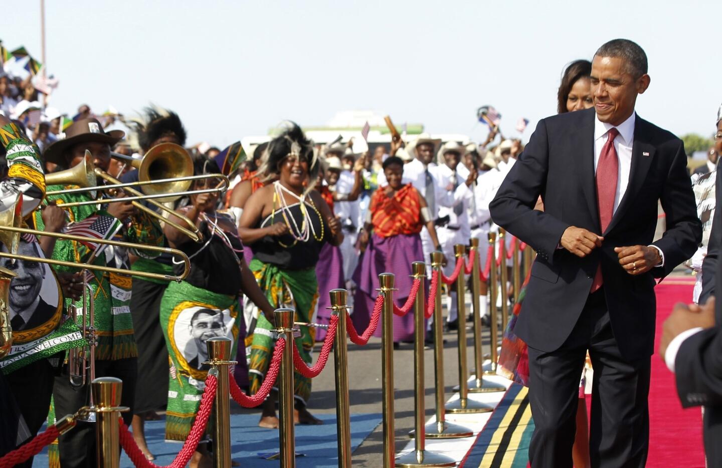 U.S. President Obama dances as a Tanzanian band plays during an official arrival ceremony at Julius Nyerere Airport in Dar es Salaam