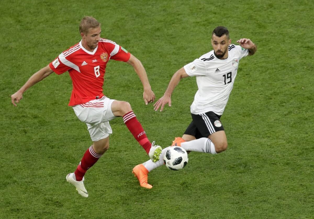 Russia's Yuri Gazinsky, left, and Egypt's Abdalla Said challenge for the ball during a World Cup Group A match on June 19.