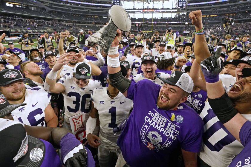 Kansas State players celebrate with the trophy after winning the Big 12 Conference championship NCAA college football game against TCU, Saturday, Dec. 3, 2022, in Arlington, Texas. (AP Photo/LM Otero)