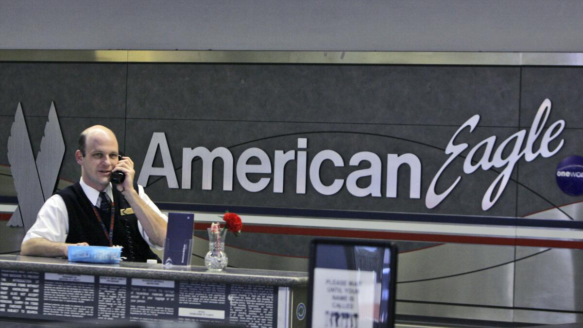 An American Eagle employee talks on the phone at Dallas Fort Worth International Airport. The idea of adding five more seats on regional jets was offered and then dropped during contract negotiations.