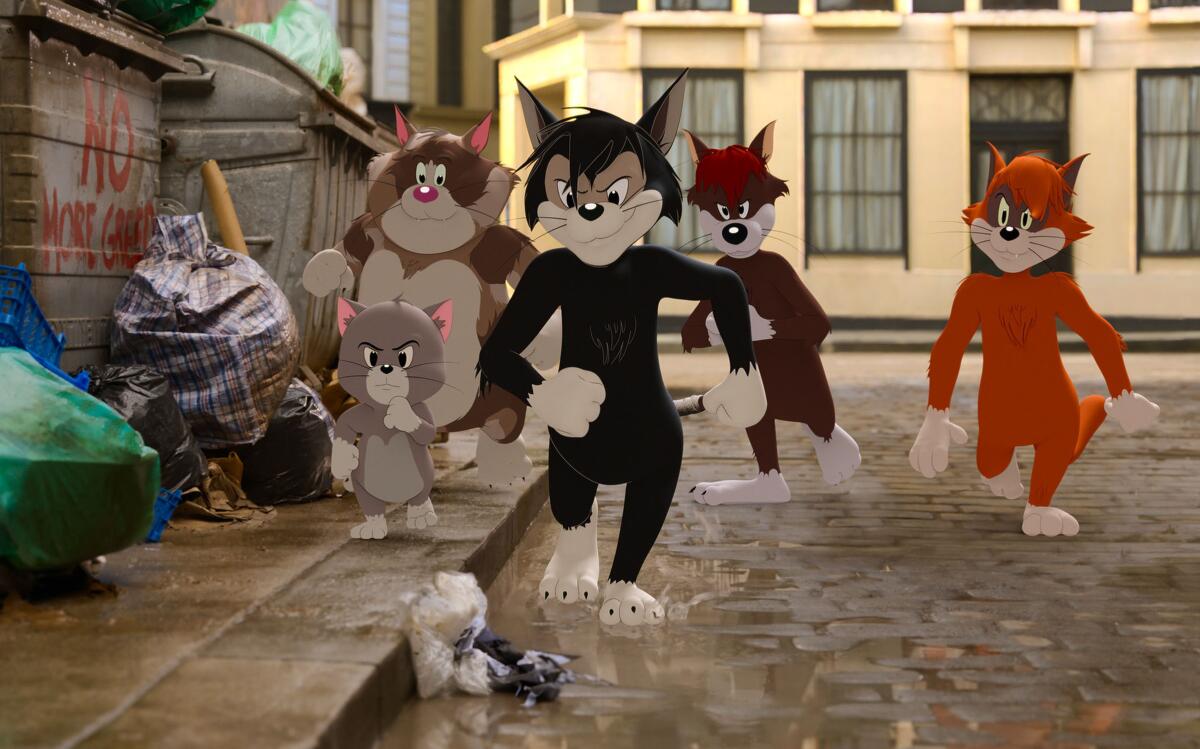 A group of animated alley cats walk down the street in "Tom & Jerry."