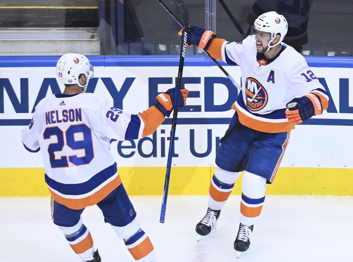 New York Islanders right wing Josh Bailey (12) celebrates his goal with teammate Brock Nelson (29) after scoring against the New York Islanders during the third period NHL Eastern Conference Stanley Cup playoff hockey game in Toronto on Wednesday, Aug. 12, 2020. (Nathan Denette/The Canadian Press via AP)