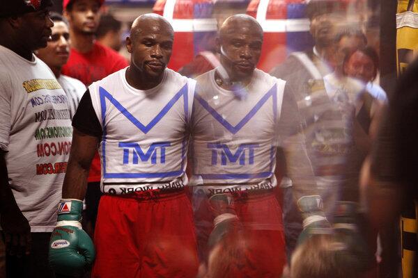 Boxing champion Floyd Mayweather Jr. is reflected in a mirror during a training session at his gym in Las Vegas. The double-image is made in the beveled edge of a mirror.