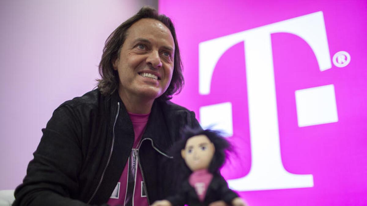 John Legere, CEO de T-Mobile sostiene un muñeco a su imagen y semejanza durante un evento mediático en el año 2014.