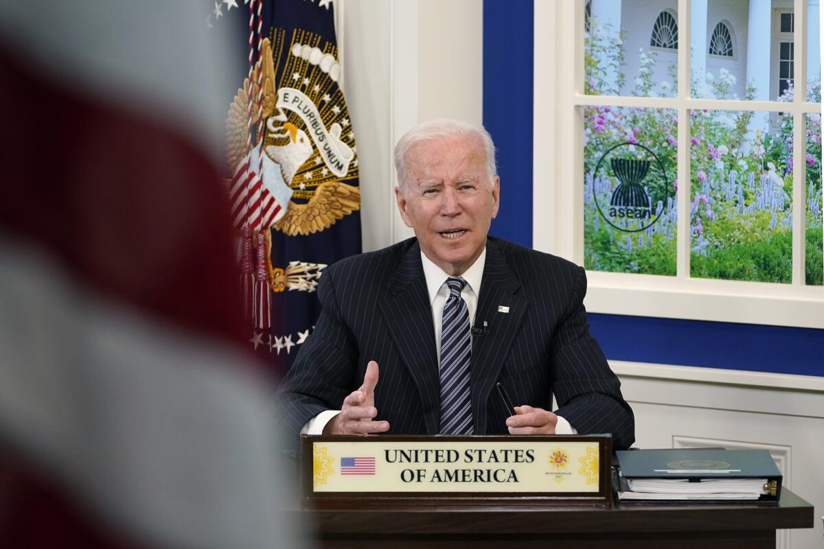 President Biden speaks, seated at a desk