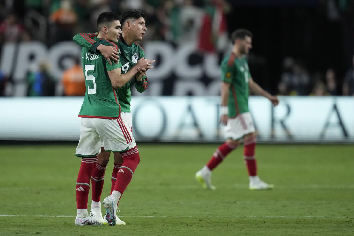 Johan Vázquez y Edson Álvarez, de México se abrazan tras la victoria sobre Jamaica