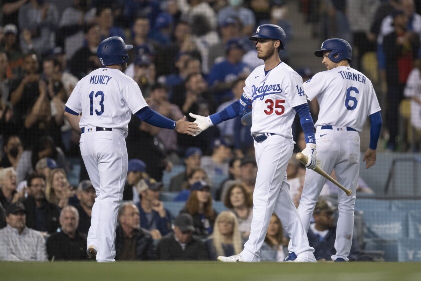 Cody Bellinger of the Dodgers greets Max Muncy and Trea Turner, who scored on a Will Smith brace.