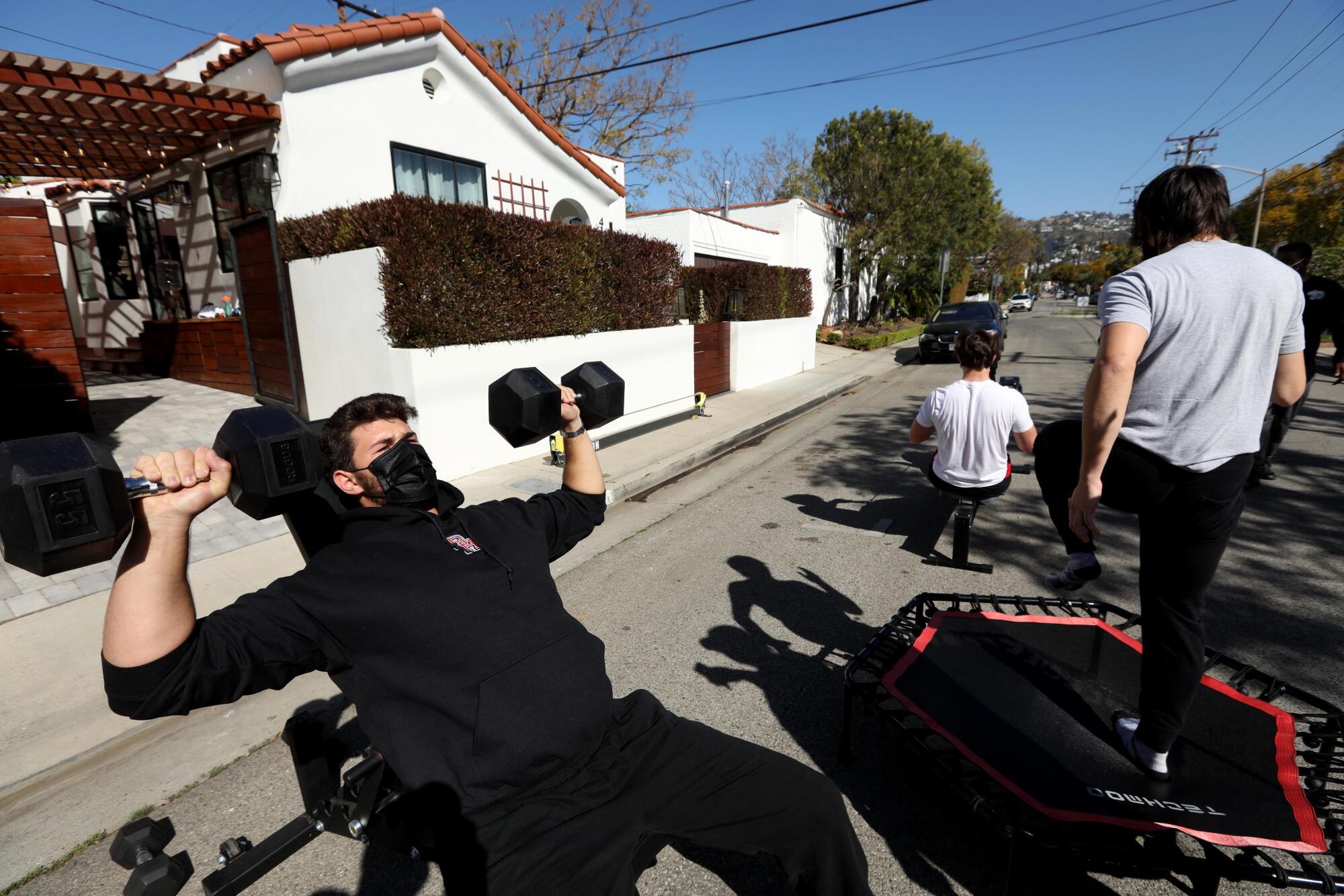 Max Menache, left, works outs with his brother Dan and his friend Jackson Herseu.