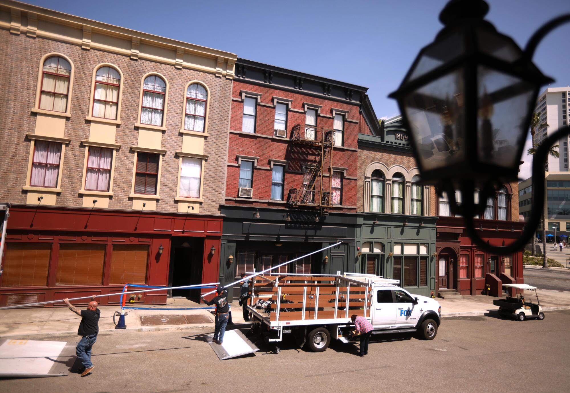 A film crew unloads a truck as they get ready for a shoot at the new New York set at Fox Studios in Los Angeles.