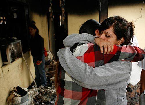 A house fire in Rialto early Friday left two boys dead. They were brothers David and Mario Cisneros, ages 4 and 5, respectively. At the home, an aunt, Rosana Delgado, left, is hugged by Jennie Rosales.