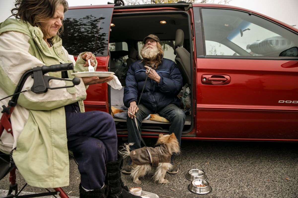 DeAnn Miller and Ron Irick eat breakfast in a Walmart parking lot in Chico that has become a temporary shelter for Camp fire evacuees.