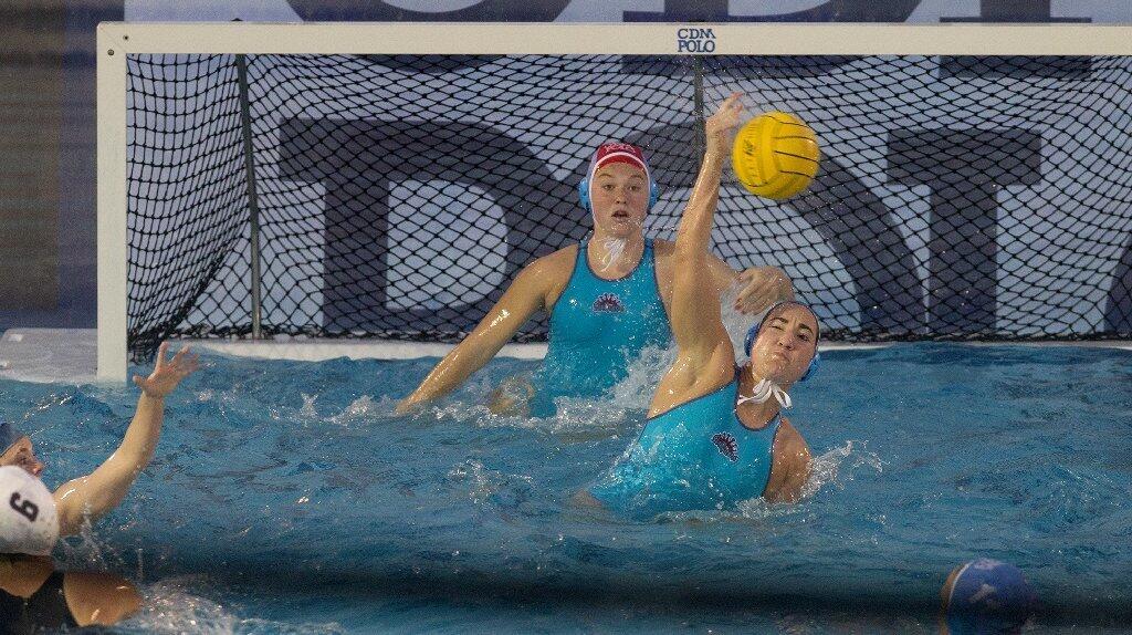 Corona del Mar High's Chloe Harbilas, bottom, gets a field block during the second half against Newport Harbor.