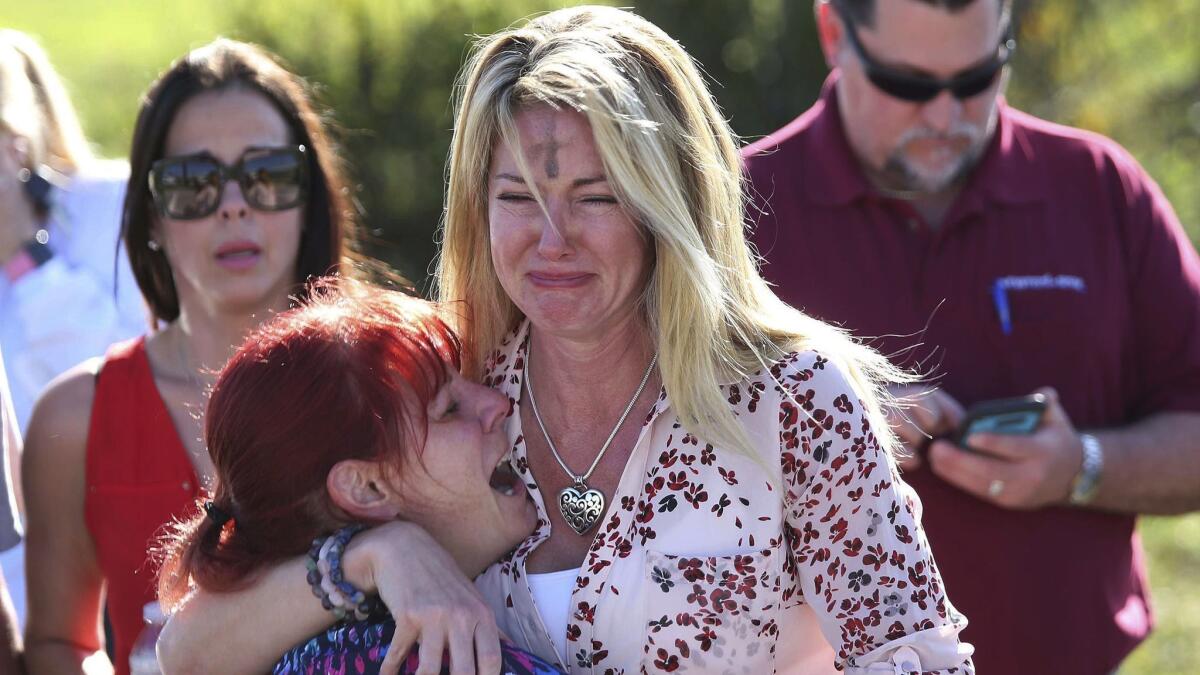 In this Feb. 14, 2018 photo, parents wait for news after a reports of a shooting at Marjory Stoneman Douglas High School in Parkland, Fla.