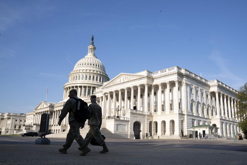 The U.S. Capitol is seen as national guard members pass by on Capitol Hill in Washington, Thursday, May 20, 2021. The House voted to create an independent commission on the deadly Jan. 6 insurrection at the U.S. Capitol, sending the legislation to an uncertain future in the Senate. (AP Photo/Jose Luis Magana)