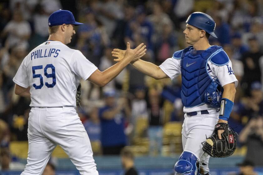Los Angeles Dodgers relief pitcher Evan Phillips, left, celebrates with catcher Will Smith.