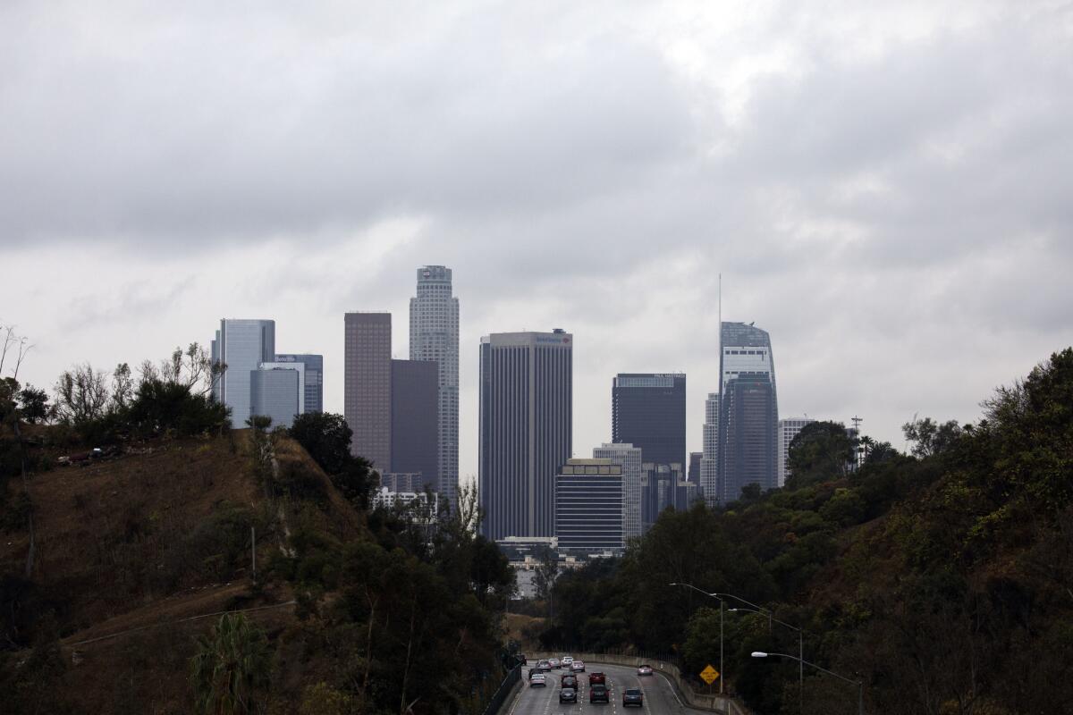 Clouds surround the downtown Los Angeles skyline as seen above the 110 Freeway.