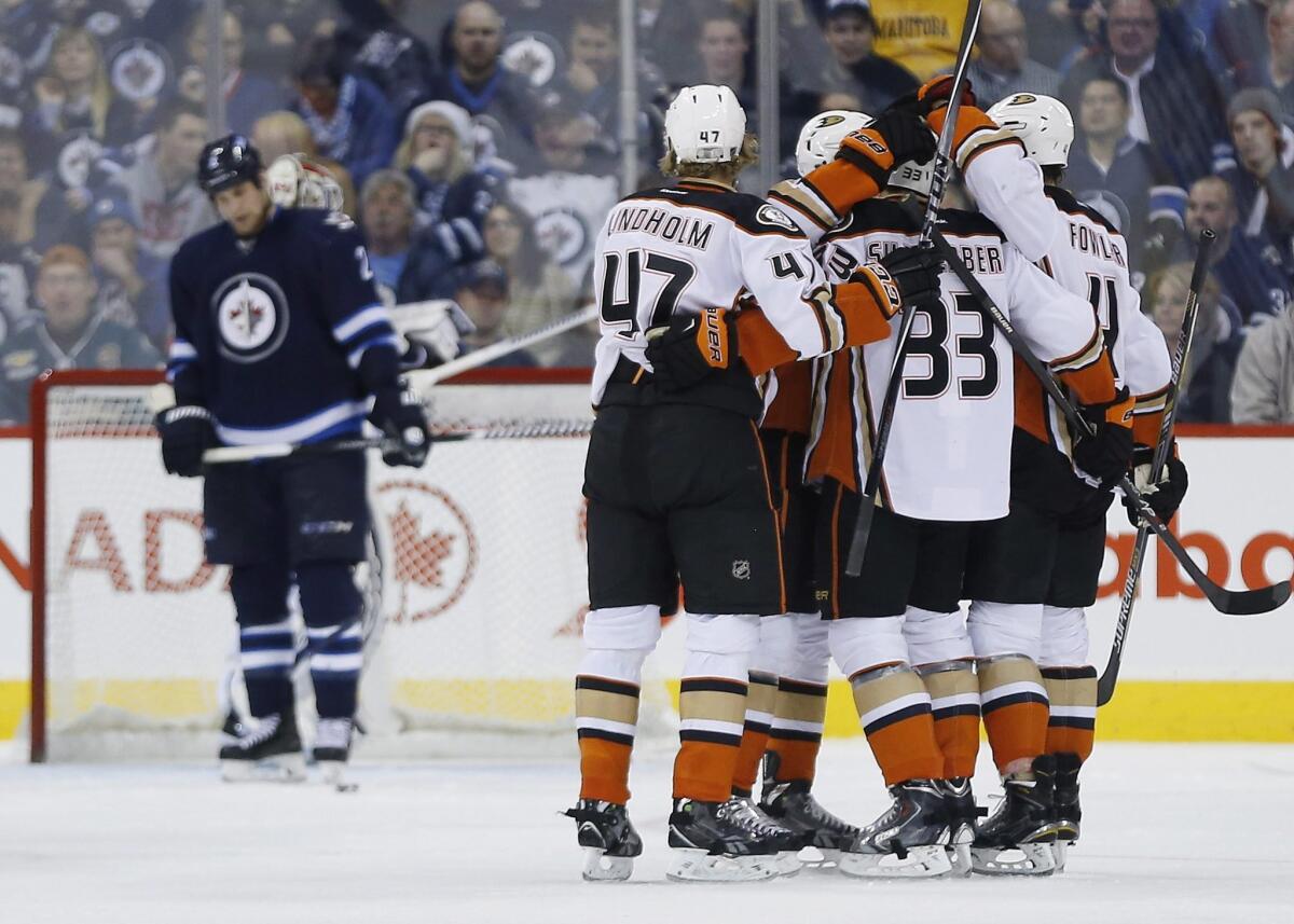 The Ducks celebrate a goal by Jakob Silfverberg (No. 33) Saturday night in Winnipeg. At left is the Jets' Blake Wheeler.