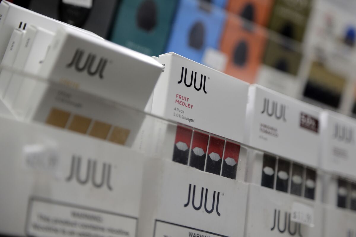 FILE - Juul products are displayed at a smoke shop in New York, on Dec. 20, 2018. Tobacco giant Altria said Tuesday, Feb. 15, 2022, that an administrative law judge has dismissed a federal lawsuit alleging the company's partnership with e-cigarette maker Juul Labs amounted to an anticompetitive agreement that hurt consumers. (AP Photo/Seth Wenig, File)