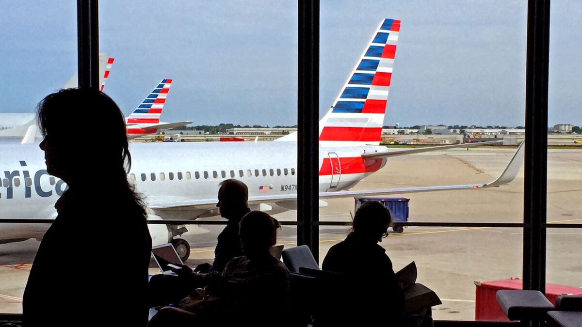 Travelers at Chicago O'Hare International Airport await their flights at the American Airlines terminal. The airline has unveiled a "basic economy" fare to compete with low-cost carriers.