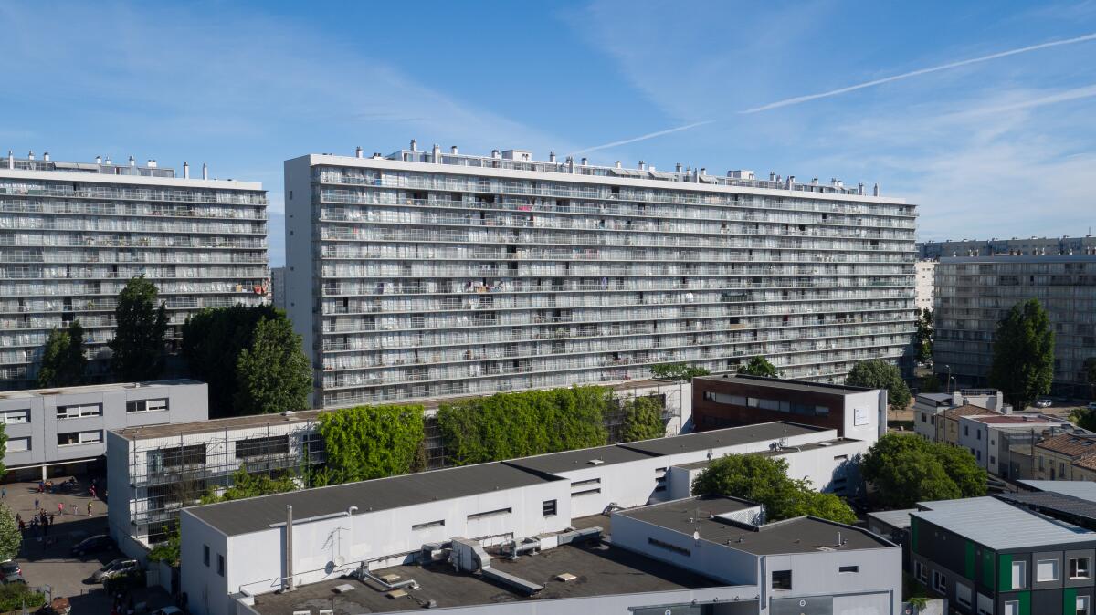 A wide view of a '60s-era housing block is seen after a renovation that added terraces