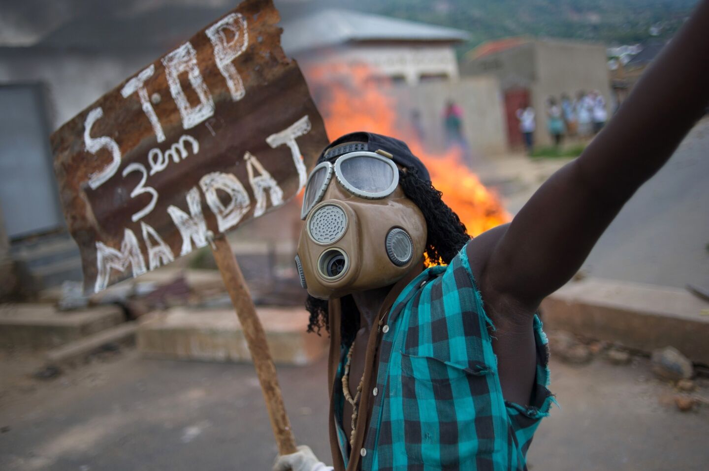 A Burundian man protesting the president's bid for a third term chants near a burning barricade May 6 in the Mugasa neighborhood of Bujumbura.