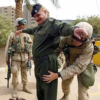 Ahmad Zaki Abd Razaq, an assistant to the former head of police in Baghdad, is patted down by a U.S. Marine before being allowed to enter the Palestine Hotel. He offered to help U.S. troops reactivate the police force in the capital.