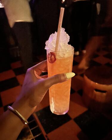 Strawberry milk cocktail held in a guest's hand