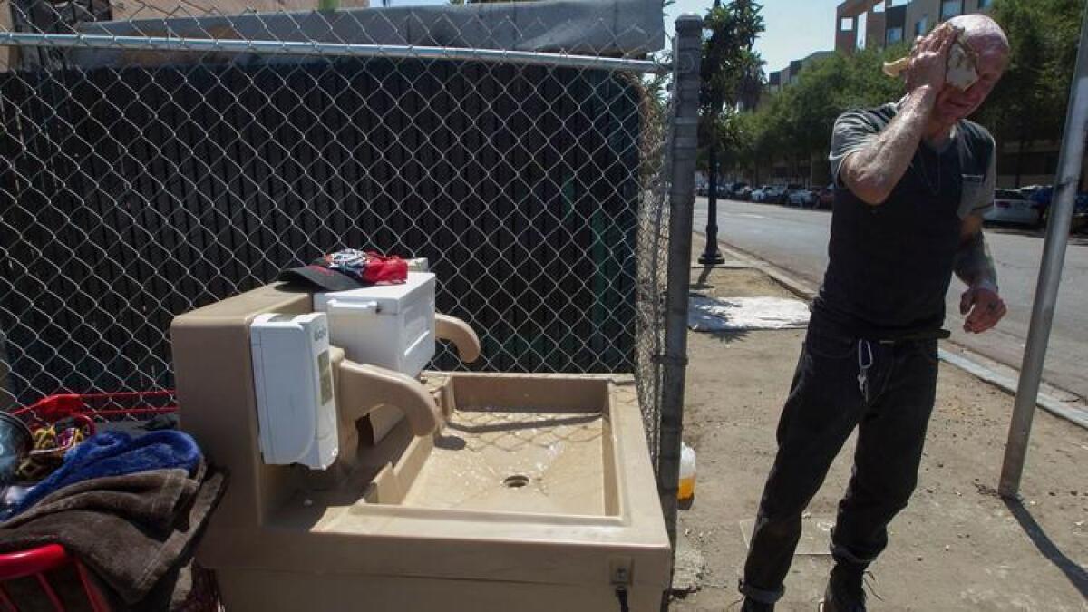 Estación de lavado de manos en San Diego. Jaime Lynn Hines se lava las manos y la cara en una de las estaciones de higiene instaladas por el condado en un intento por detener la propagación de la hepatitis A en San Diego.