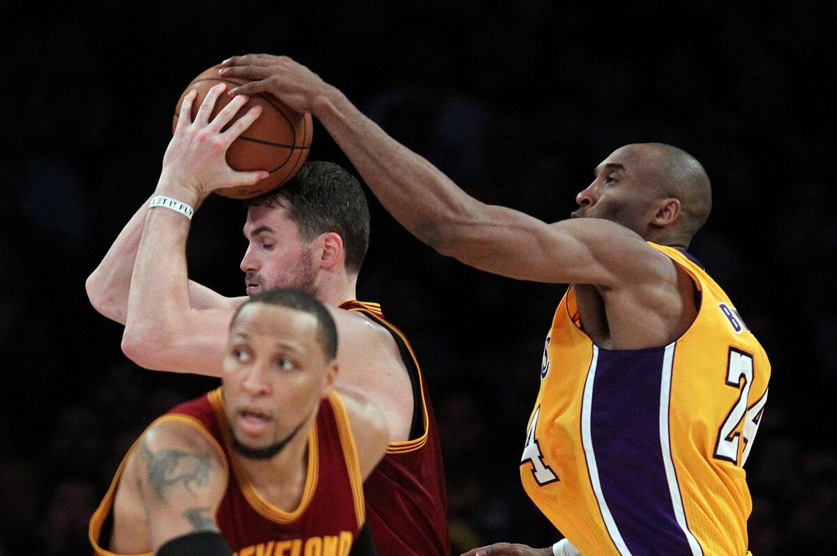 Lakers guard Kobe Bryant gets all ball as he tries to steal the ball from Cavaliers forward Kevin Love.