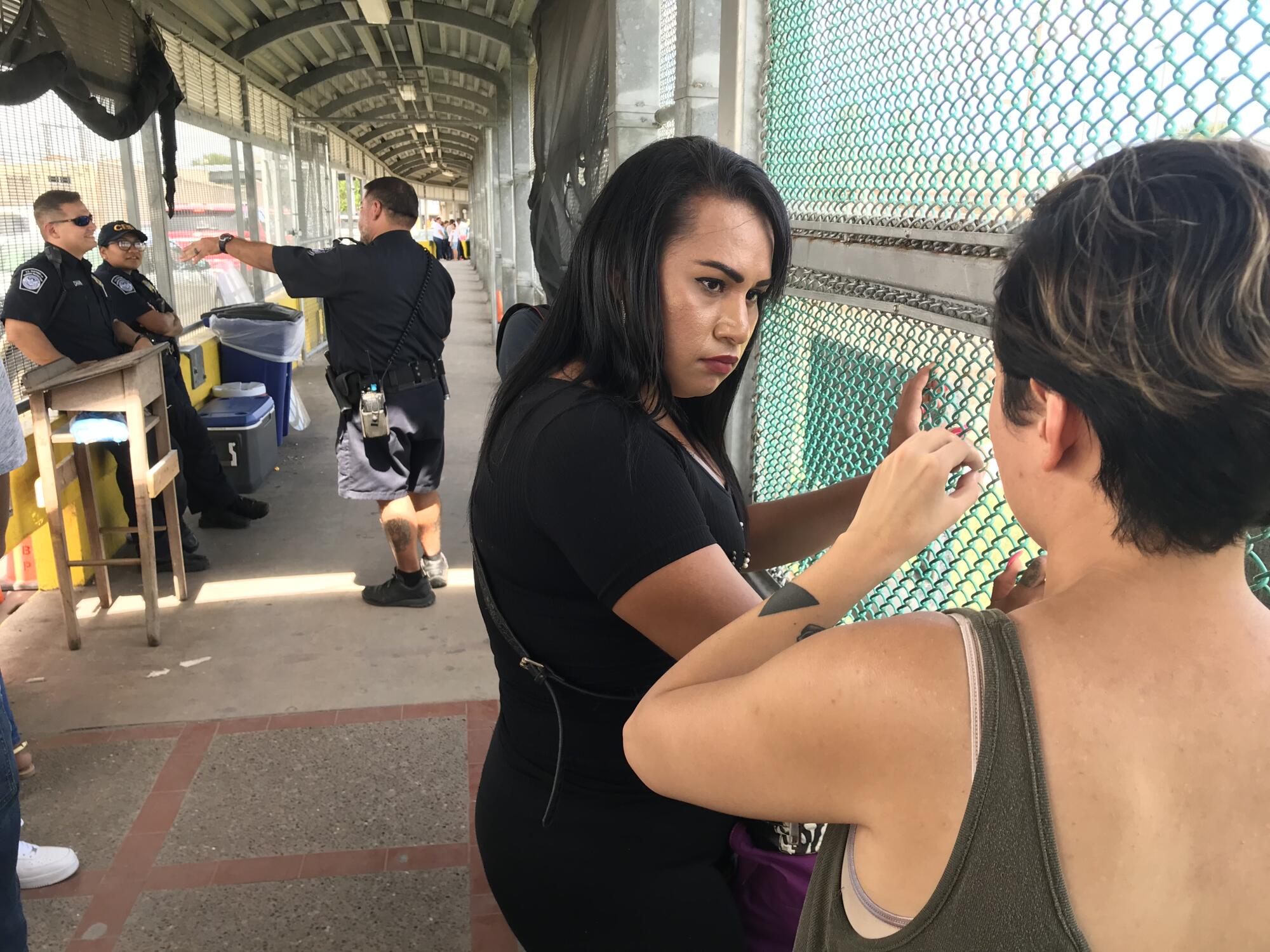La migrante salvadoreña Mayela Villegas consulta con Dani Marrero Hi, miembro del Proyecto de Derechos Civiles de Texas, en el puente fronterizo desde Matamoros, México, hasta Brownsville, Texas.