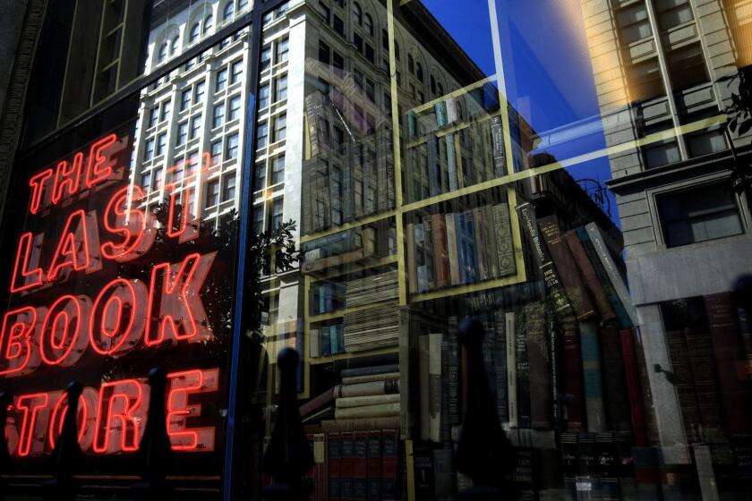 LOS ANGELES ,CA., MARCH 30 2019: The neon sign in the window of the Last Bookstore reflects the past and present on the corner of Spring Street and 5th in downtown Los Angeles March 30, 2019. While bookstores continue to shut their doors, The Last Bookstore which is housed in the former Crocker Bank building has grown to over 22,000 square feet of space with over 250,000 new and used books and vinyl (Mark Boster For the LA Times).