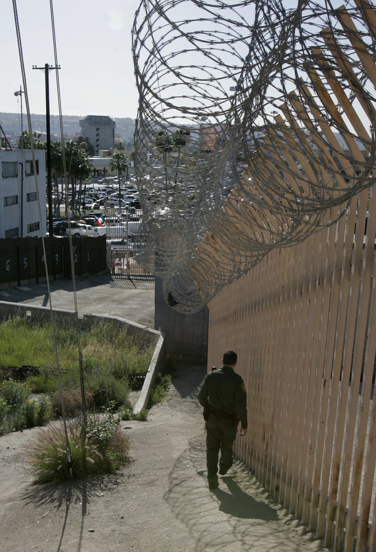 March 9, 2011, San Ysidro border crossing, California, USA_Border Patrol Agent Rodolfo Zuniga walks along the secondary fence just east of the San Ysidro border crossing. Photo Credit: CHARLIE NEUMAN/San Diego Union-Tribune/ZUMA Press