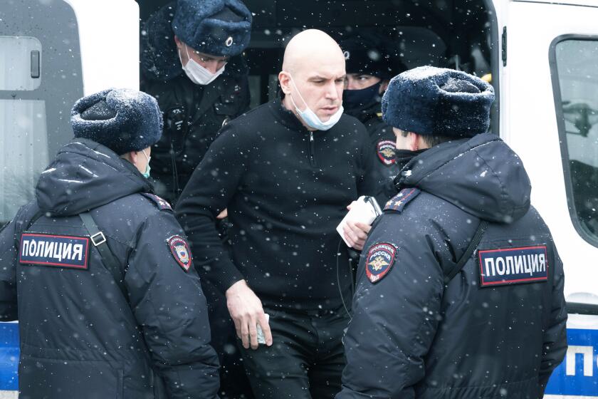 A detainee exits a police bus in Moscow on Saturday.  
