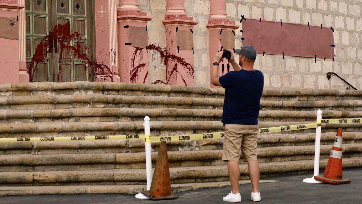 German tourist Lars Urbanschulze takes photos of vandalism at the Old Mission Santa Barbara on Oct. 10.