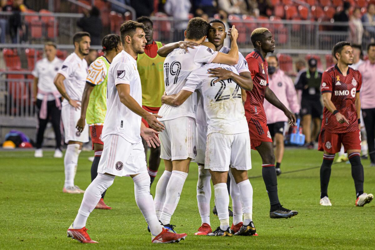 Inter Miami forward Federico Higuain (22), forward Robbie Robinson (19) and defender Christian Makoun celebrate after the team's win over Toronto FC in an MLS soccer match Tuesday, Sept. 14, 2021, in Toronto. (Christopher Katsarov/The Canadian Press via AP)