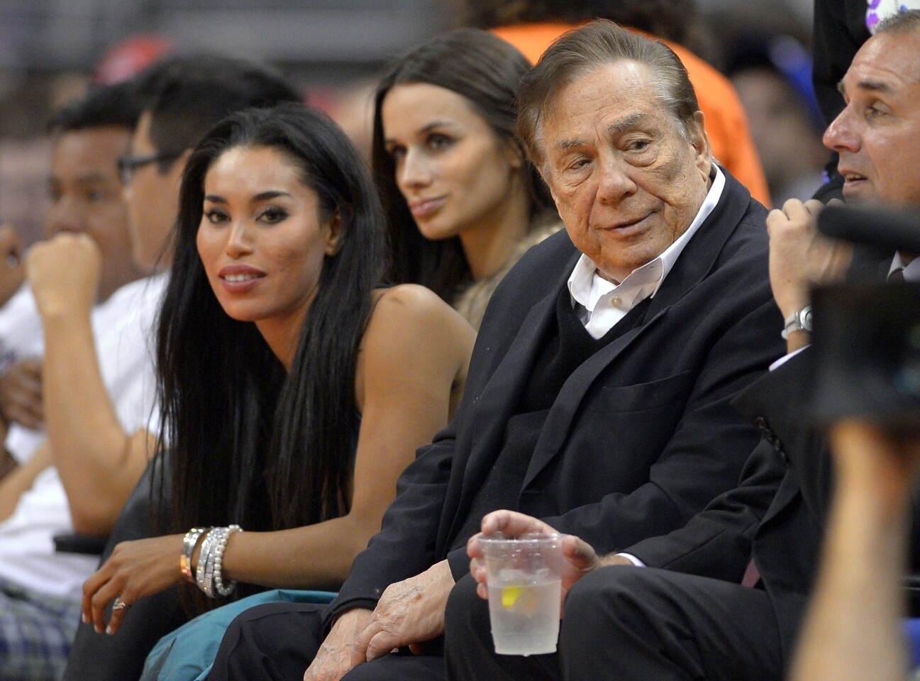 Los Angeles Clippers owner Donald Sterling, right, and V. Stiviano, left, watch the Clippers play the Sacramento Kings during an exhibition game earlier this season at Staples Center.