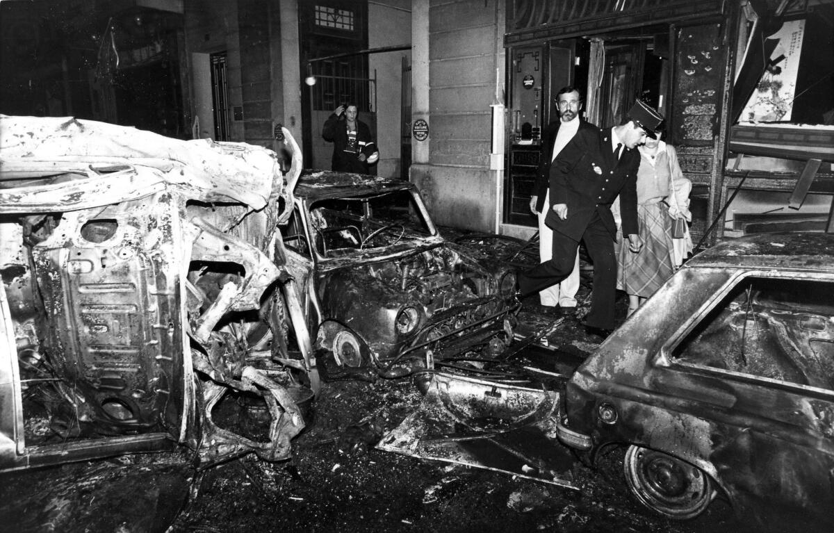 black and white photos of destroyed vehicles and damaged building at synagogue in Paris