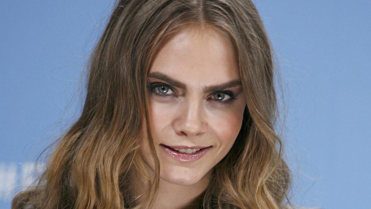 Cara Delevingne's love life has her feeling "so happy" these days about who she is, she tells Vogue.