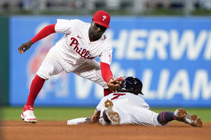 Philadelphia Phillies shortstop Didi Gregorius, left, tags out Atlanta Braves' Dansby Swanson after he tried to steal second during the seventh inning of a baseball game, Tuesday, July 26, 2022, in Philadelphia. (AP Photo/Matt Slocum)