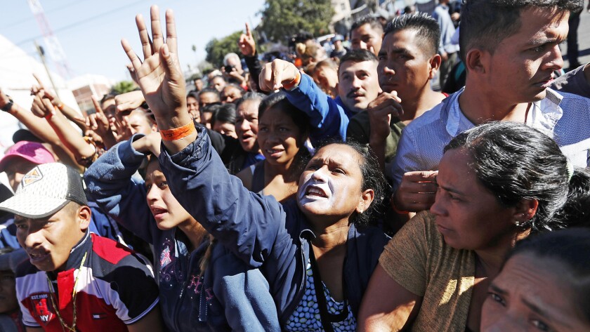 Central American migrants wait to receive food and clothing after arriving in Tijuana on Friday.