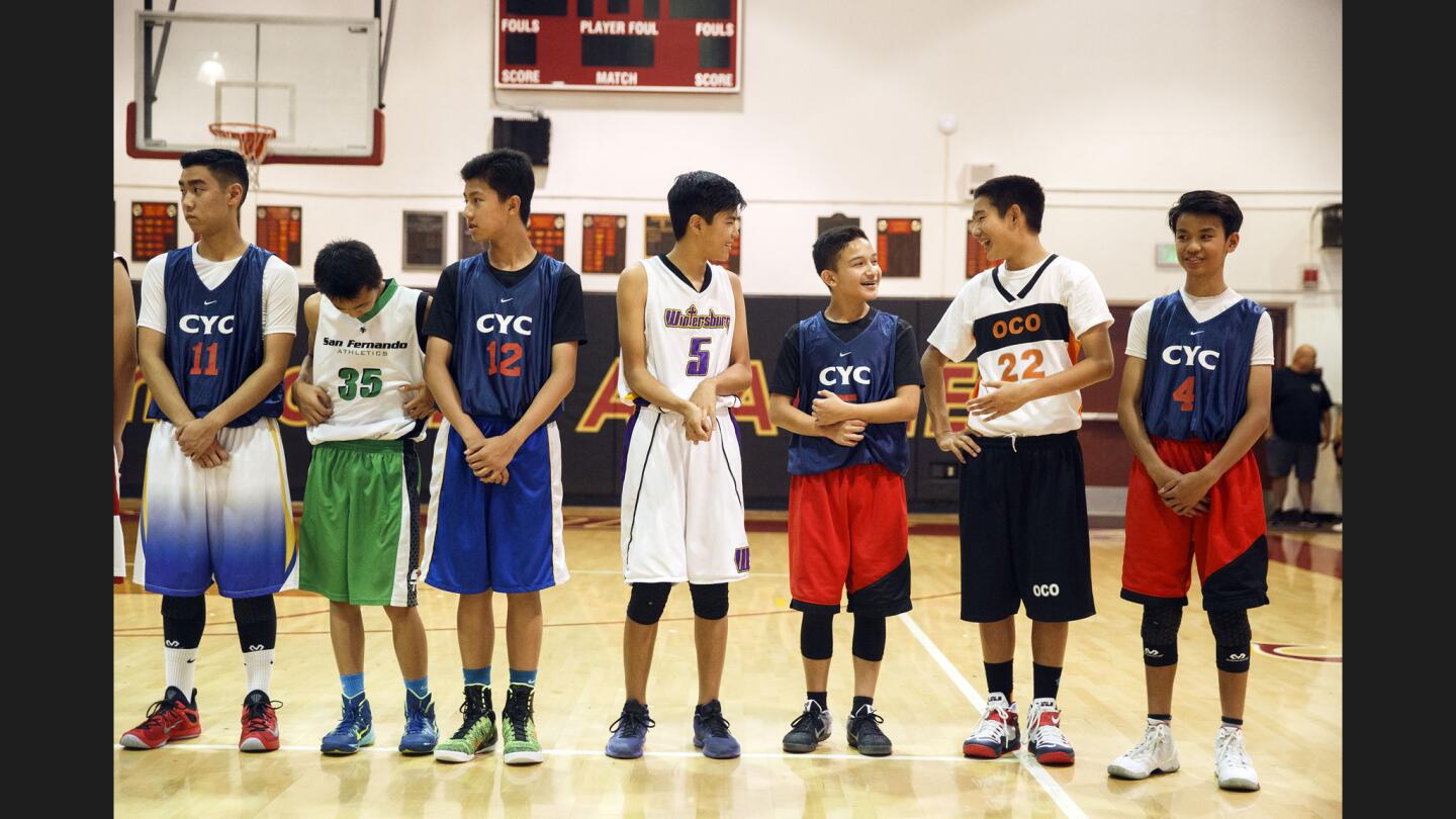 Members of the Yonsei 23 team and the CYC All Stars line up for a group picture before their basketball game at Arcadia High School on June 25, 2016. An effort is underway to build a sports facility in Little Tokyo to draw younger Japanese Americans such as these players to the district.