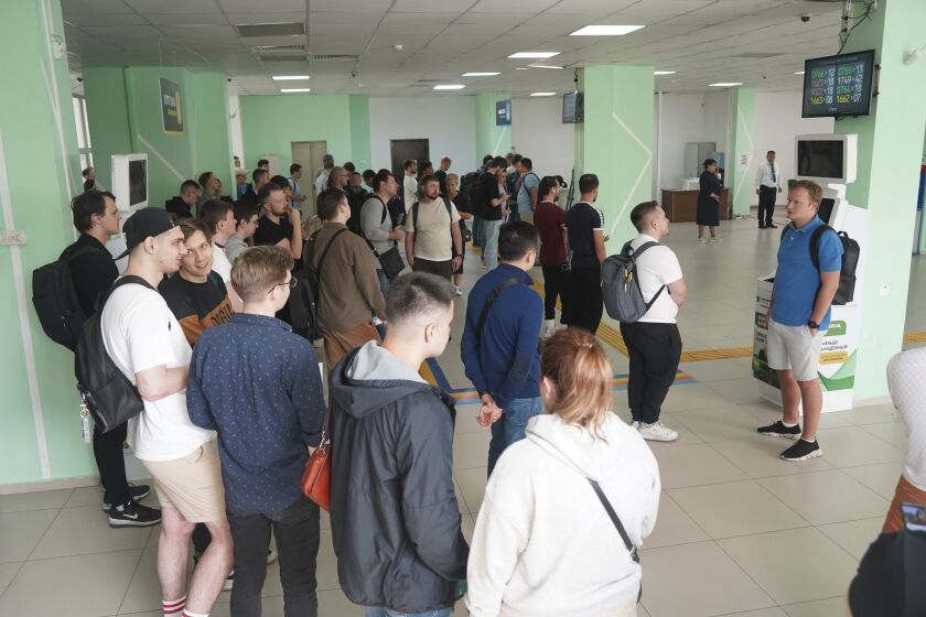 Russians lineup to get Kazakhstan's a Personal Identification Number (INN) in a public service center in Almaty, Kazakhstan, Tuesday, Sept. 27, 2022. A day after President Vladimir Putin ordered a partial mobilization to bolster his troops in Ukraine, many Russians are leaving their homes. (Vladimir Tretyakov/NUR.KZ via AP)