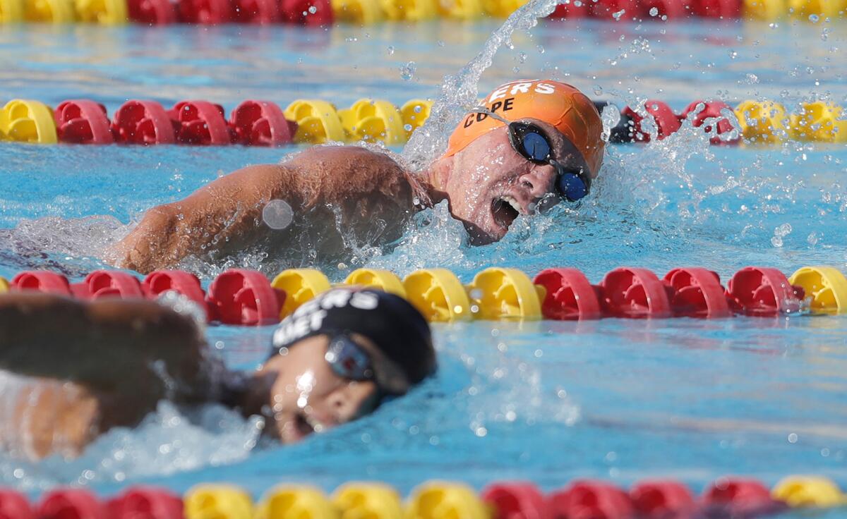 Grahm Cope of Huntington Beach (orange cap) and Brendan Pham swim side by side in the swimming league finals on Friday.