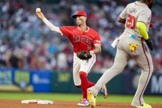 Los Angeles Angels shortstop Zach Neto, left, throws out Atlanta Braves' Travis d'Arnaud.