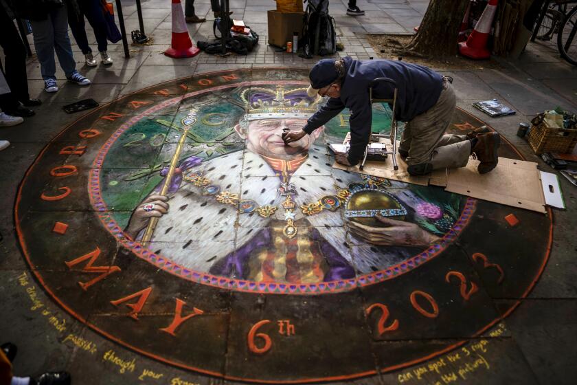 British Artist Julian Beaver gives the finishing touches to his work based on an image of King Charles III in London, Thursday, May 4, 2023. The Coronation of King Charles III will take place at Westminster Abbey on May 6. (AP Photo/Emilio Morenatti)