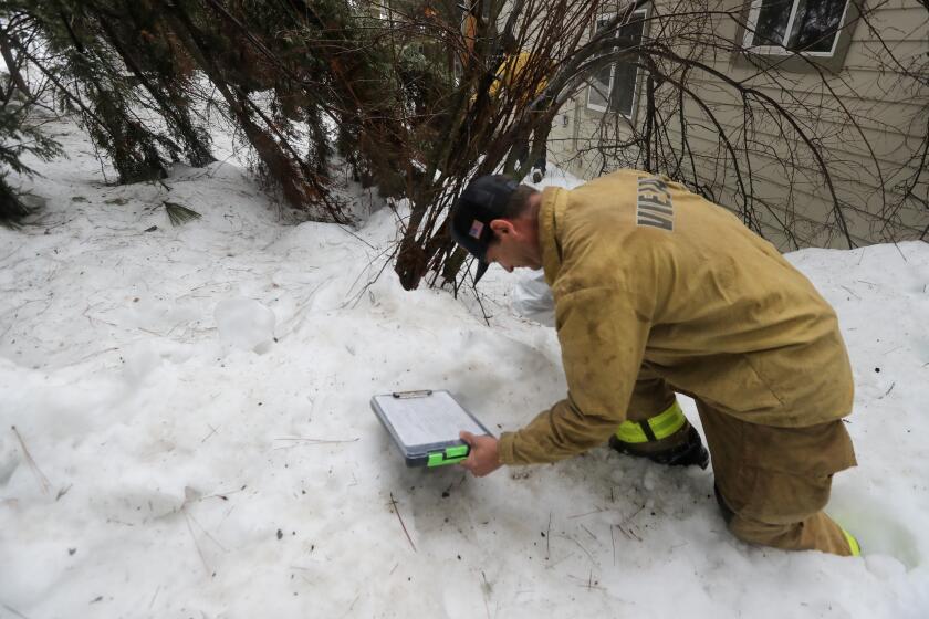 LAKE ARROWHEAD, CA - MARCH 10: Fire line medic Aaron Thomas postholes through deep snow to deliver medicine to Lexi Searles' snowed-in home on Friday, March 10, 2023 in Lake Arrowhead, CA. (Brian van der Brug / Los Angeles Times) Verb posthole (third-person singular simple present postholes, present participle postholing, simple past and past participle postholed)