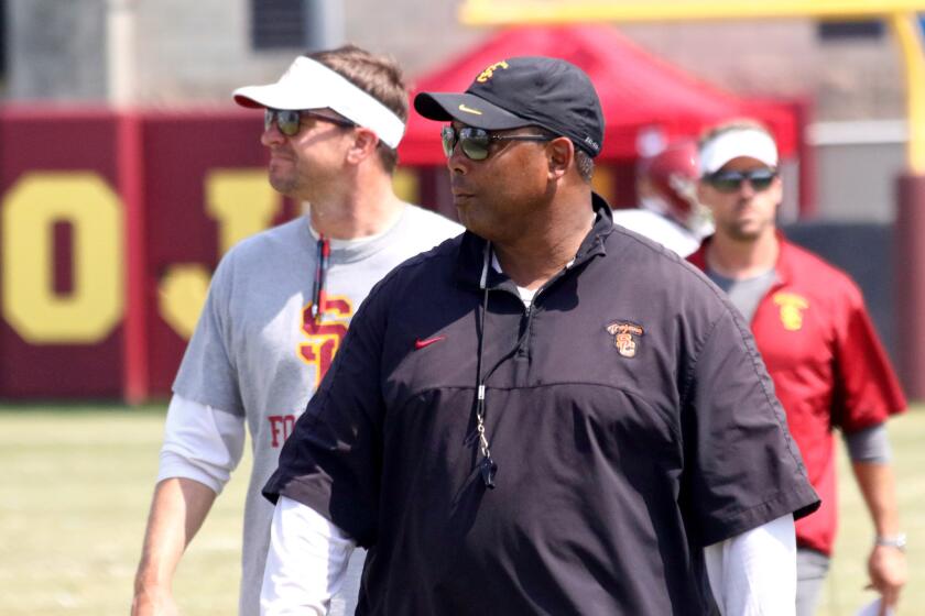 Then a USC defensive line coach, Chris Wilson, center, is shown at a fall practice. He was fired in December.