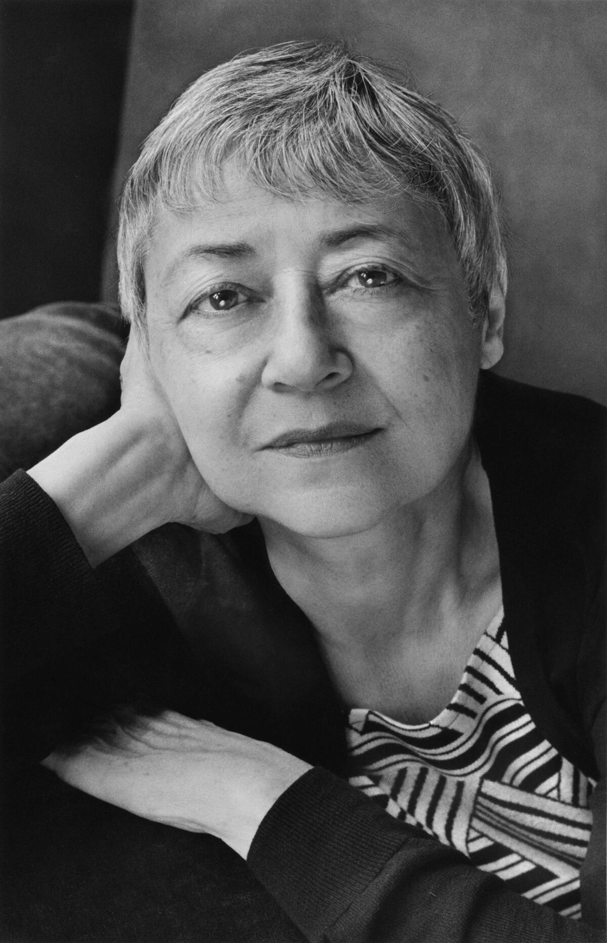 Sigrid Nunez, an author, poses in a black and white photo with short gray hair and an enigmatic smile.