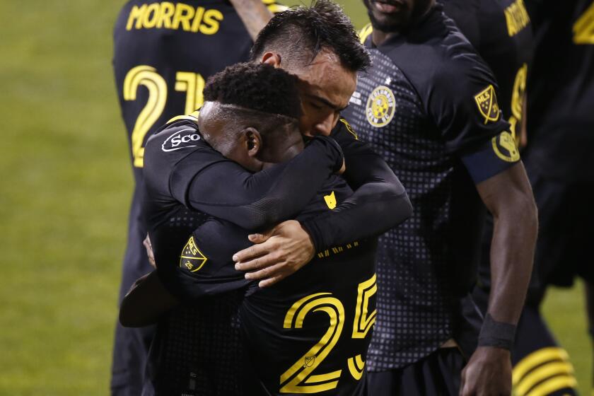 Columbus Crew's Lucas Zelarayan, top, celebrates his goal against the Seattle Sounders with Harrison Afful.