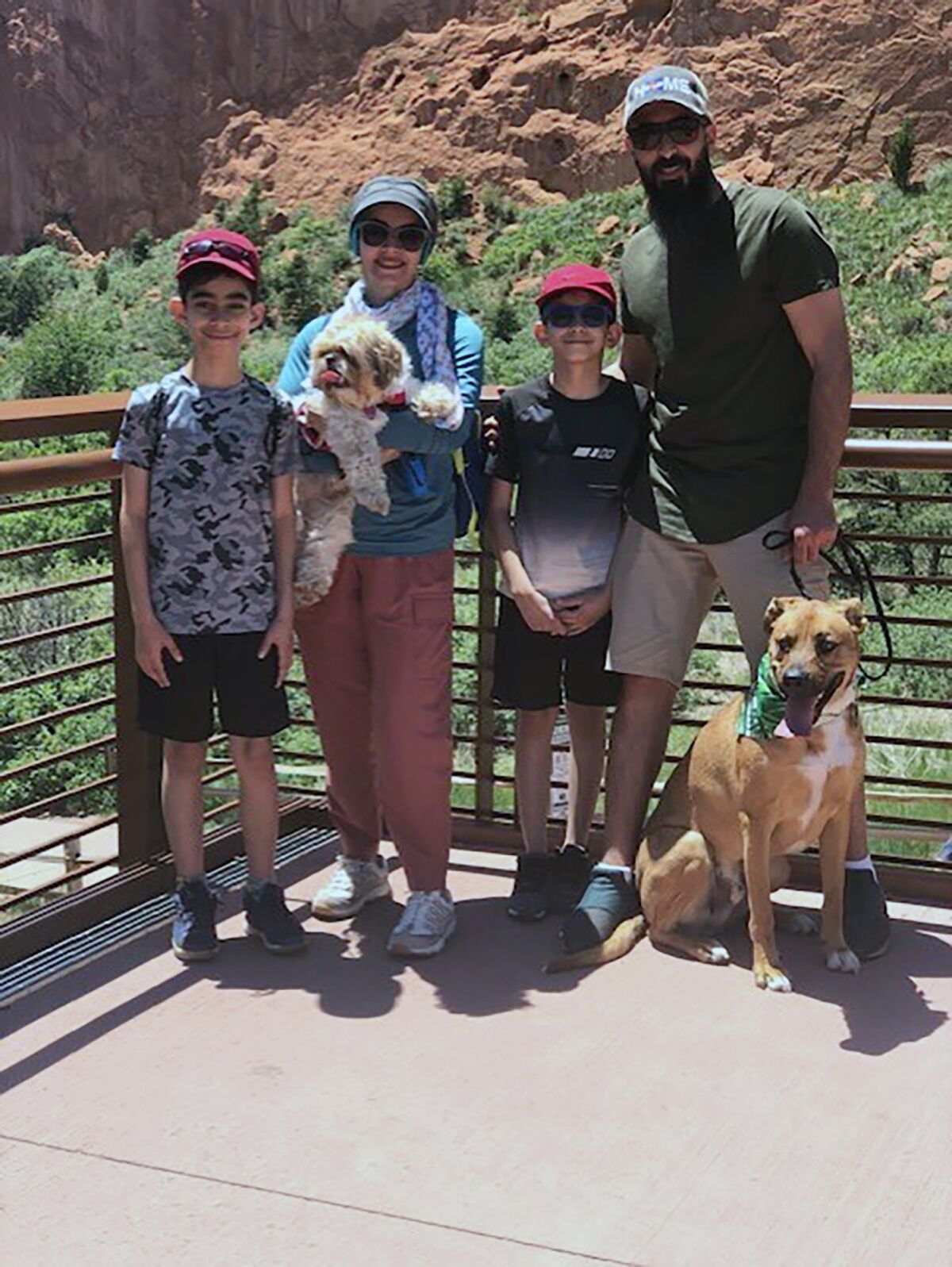 In this provided photo, the Alkhafajis family, from left to right: Jay, Rasha and their dog, Ganosh, Ali, Mousa and their dog, Hero pose for a picture at the Garden of the Gods in Colorado Springs, Colorado. Thousands of Airbnb hosts have agreed to house refugees as part of the online lodging marketplace’s philanthropic program to provide emergency temporary housing to those who need it. (Courtesy of Mousa Alkhafaji via AP)